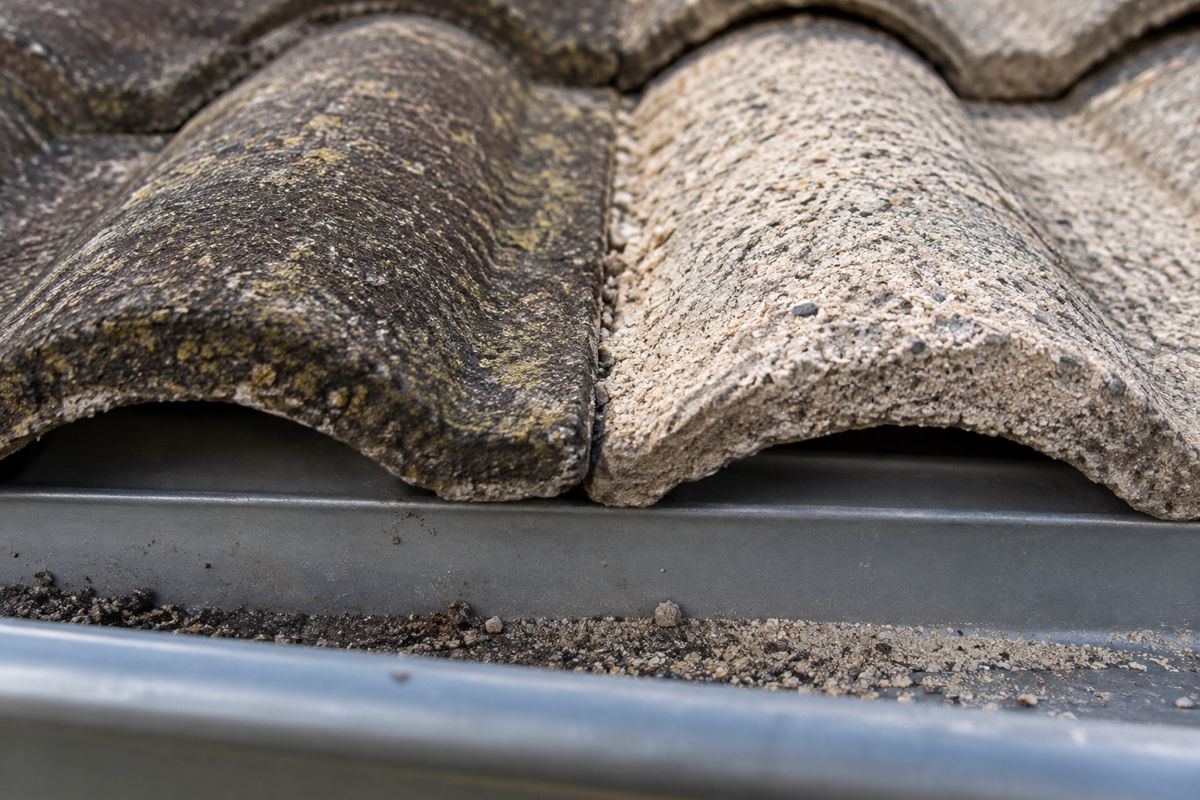 Two roof tiles side by side showing worn surface coating